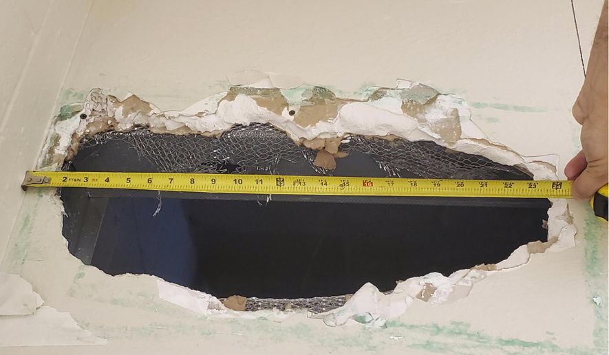This photo provided Monday, Nov. 4, 2019, by the Monterey County Sheriff's Office shows a hole that Santos Fonseca and Jonathan Salazar escaped through in the county jail in Salinas, Calif. Two murder suspects escaped the jail over the weekend after climbing through the hole they made in a bathroom ceiling in their housing unit and then working their way through a wall until they reached a hatch they kicked open to leave the building, an official said Monday, Nov. 4, 2019. (Monterey County Sheriff's Office via AP)