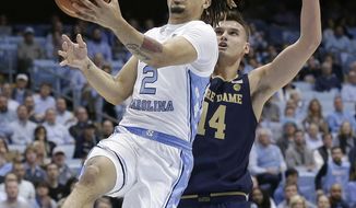North Carolina guard Cole Anthony (2) drives to the basket while Notre Dame forward Nate Laszewski (14) defends during the first half of an NCAA college basketball game in Chapel Hill, N.C., Wednesday, Nov. 6, 2019. (AP Photo/Gerry Broome)