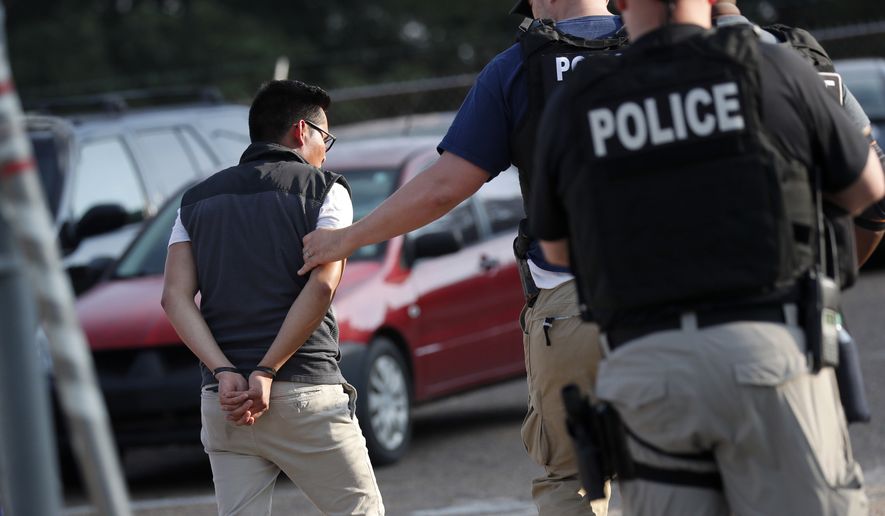 A man is taken into custody at a Koch Foods Inc. plant in Morton, Miss., on Wednesday, Aug. 7, 2019.  U.S. immigration officials raided several Mississippi food processing plants on Wednesday and signaled that the early-morning strikes were part of a large-scale operation targeting owners as well as employees. (AP Photo/Rogelio V. Solis)