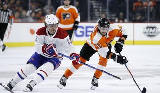 Philadelphia Flyers&#x27; Travis Konecny (11) and Montreal Canadiens&#x27; Max Domi (13) battle for the puck during the second period of an NHL hockey game, Thursday, Nov. 7, 2019, in Philadelphia. (AP Photo/Matt Slocum)