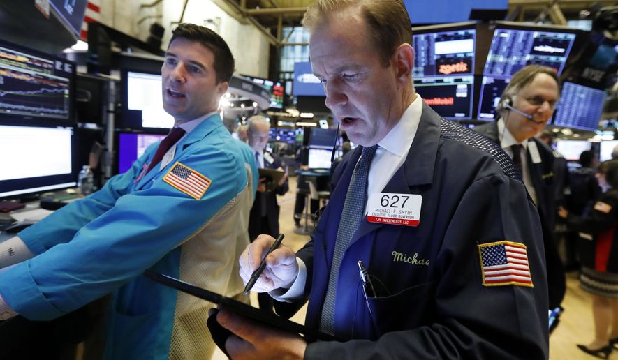 FILE - In this Oct. 30, 2019, file photo specialist Thomas McArdle, left, and trader Michael Smyth, center, work on the floor of the New York Stock Exchange. The U.S. stock market opens at 9:30 a.m. EST on Thursday, Nov 7. (AP Photo/Richard Drew, File)