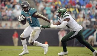 Jacksonville Jaguars running back Leonard Fournette (27) escapes a tackle by New York Jets outside linebacker Brandon Copeland, right, during the first half of an NFL football game, Sunday, Oct. 27, 2019, in Jacksonville, Fla. (AP Photo/Phelan M. Ebenhack)