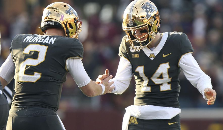 Minnesota quarterback Tanner Morgan (2) celebrates with teammate Casey O'Brien (14) after their team scored a touchdown against Maryland during an NCAA college football game Saturday, Oct. 26, 2019, in Minneapolis. (AP Photo/Stacy Bengs)