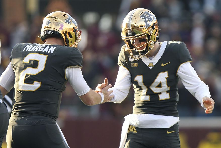 Minnesota quarterback Tanner Morgan (2) celebrates with teammate Casey O'Brien (14) after their team scored a touchdown against Maryland during an NCAA college football game Saturday, Oct. 26, 2019, in Minneapolis. (AP Photo/Stacy Bengs)