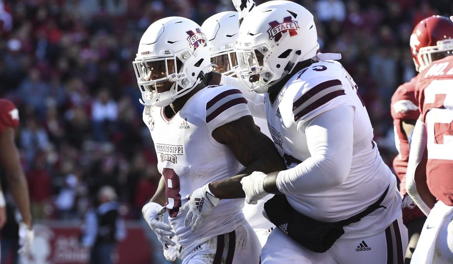 Mississippi State running back Kylin Hill (8) celebrates with teammate Darryl Williams (73) after scoring a touchdown against Arkansas during the first half of an NCAA college football game, Saturday, Nov. 2, 2019, in Fayetteville, Ark. (AP Photo/Michael Woods)