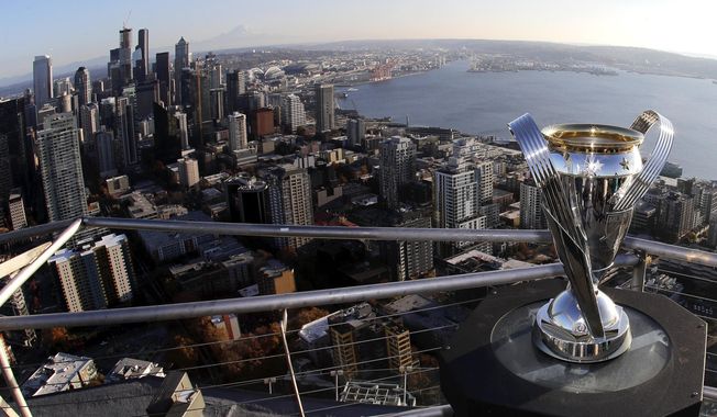 In this Nov. 5, 2019, photo, the MLS Cup trophy is displayed on the roof of the Space Needle with the downtown Seattle in the background. Seattle will host the MLS Cup soccer match Sunday, Nov. 10, 2019, as the Seattle Sounders face Toronto FC at CenturyLink Field. Ten years ago, the arrival of the Sounders changed expectations for what an MLS soccer expansion team should look like, and now the soccer-mad city gets a chance to shine hosting the league's championship game for the second time, but the first with the home team playing. (AP Photo/Ted S. Warren)