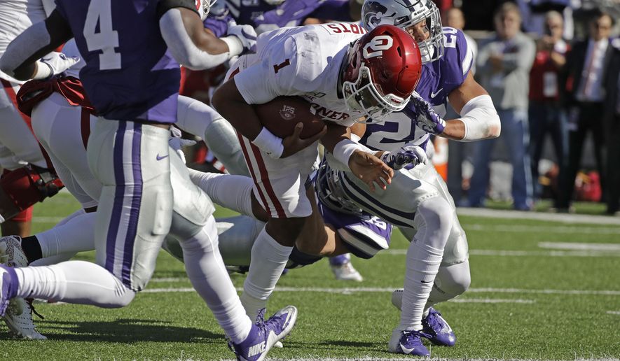 Oklahoma quarterback Jalen Hurts (1) gets past Kansas State defensive back Denzel Goolsby (20) to score a touchdown during the first half of an NCAA college football game Saturday, Oct. 26, 2019, in Manhattan, Kan. (AP Photo/Charlie Riedel)