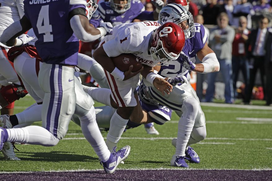 Oklahoma quarterback Jalen Hurts (1) gets past Kansas State defensive back Denzel Goolsby (20) to score a touchdown during the first half of an NCAA college football game Saturday, Oct. 26, 2019, in Manhattan, Kan. (AP Photo/Charlie Riedel)