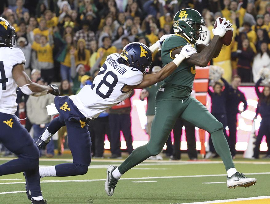 Baylor wide receiver Denzel Mims (5) catches a pass for a touchdown next to West Virginia cornerback Keith Washington Jr. (28) during the second half of an NCAA college football game in Waco, Texas, Thursday, Oct. 31, 2019. (AP Photo/Jerry Larson)
