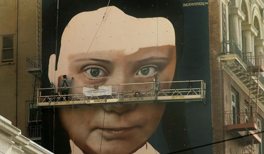 Andres Petreselli paints a mural on the side of a building depicting Swedish teen climate activist Greta Thunberg, Friday, Nov. 8, 2019, in San Francisco. (AP Photo/Ben Margot)