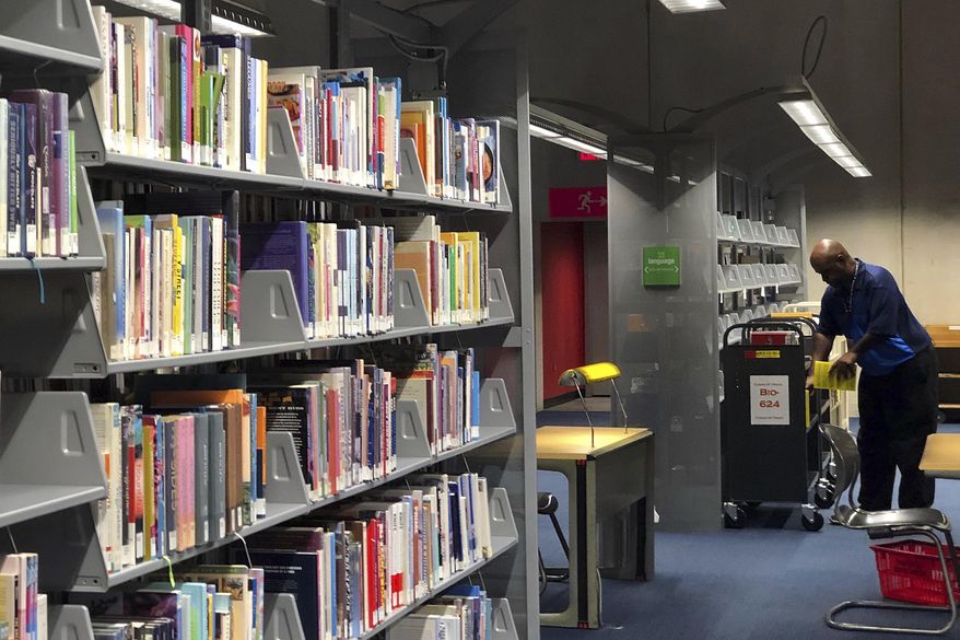 FILE - This Sept. 11, 2019, file photo, shows rows of books at the Burton Barr Central Library in Phoenix. The Phoenix Public Library system says its fine forgiveness policy takes effect Nov. 18, 2019. The City Council in September approved ending overdue fines for books, saying studies show charges on late-returned library materials do not affect how quickly they are brought back. The date the policy starts was announced Thursday, Nov. 7, 2019. (AP Photo/Anita Snow, File)