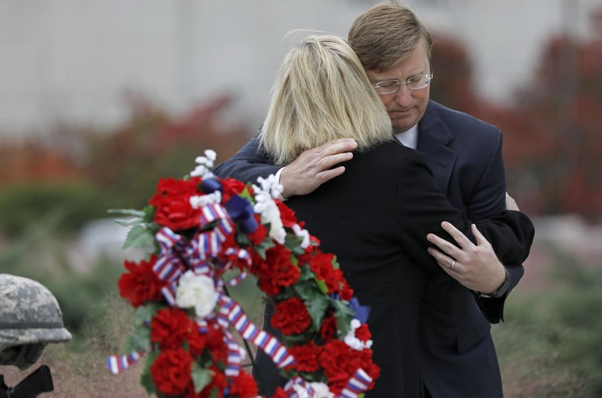 Republican Gov.-elect Tate Reeves, hugs Jenny Smith, a Gold Star mother, following a Veterans Day ceremony at the Museum of Mississippi History and Mississippi Civil Rights Museum in Jackson, Miss., Nov. 8, 2019. Smith and her husband Eddie Smith, lay a memorial wreath on Entergy Plaza outside the museums, honoring all veterans and her late son, Marine Staff Sgt. Jason A. Rogers, who was killed in an explosion two days before what would have been his 29th birthday, in April 7, 2011. (AP Photo/Rogelio V. Solis)