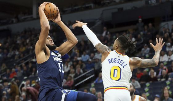 Minnesota Timberwolves&#39; Karl-Anthony Towns, left, as Golden State Warriors&#39; D&#39;Angelo Russell defends in the first half of an NBA basketball game Friday, Nov 8, 2019, in Minneapolis. (AP Photo/Jim Mone)