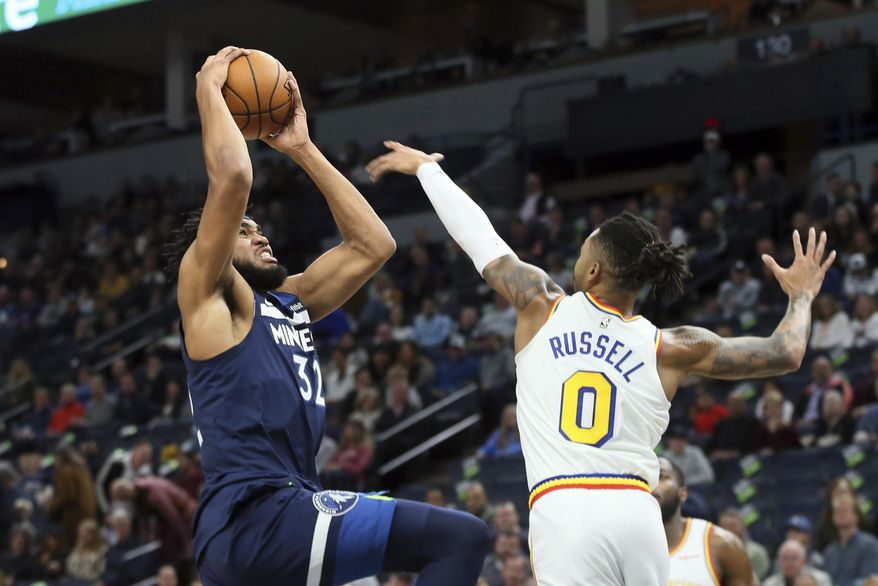 Minnesota Timberwolves&#39; Karl-Anthony Towns, left, as Golden State Warriors&#39; D&#39;Angelo Russell defends in the first half of an NBA basketball game Friday, Nov 8, 2019, in Minneapolis. (AP Photo/Jim Mone)