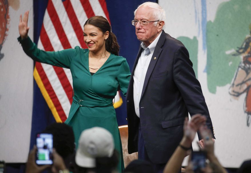 Rep. Alexandria Ocasio-Cortez, D-N.Y stands alongside Democratic presidential candidate Sen. Bernie Sanders, I-Vt., during a campaign rally on Saturday, Nov. 9, 2019, at Drake University in Des Moines, Iowa.  (Bryon Houlgrave /The Des Moines Register via AP)