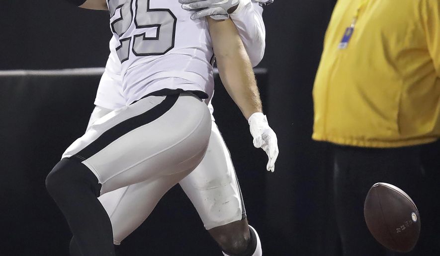 Oakland Raiders free safety Erik Harris (25) celebrates with Karl Joseph after scoring on an interception return against the Los Angeles Chargers during the first half of an NFL football game in Oakland, Calif., Thursday, Nov. 7, 2019. (AP Photo/Ben Margot)