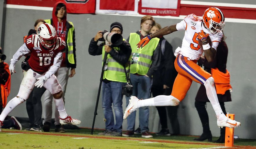 Clemson's Travis Etienne (9) breaks away from North Carolina State's Tanner Ingle (10) to score during the first half of an NCAA college football game in Raleigh, N.C., Saturday, Nov. 9, 2019. (AP Photo/Karl B DeBlaker)