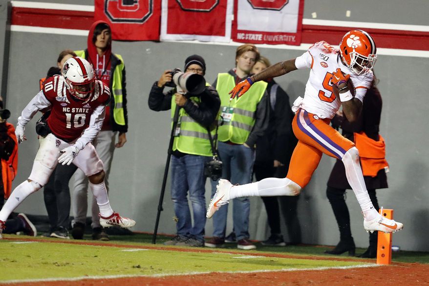 Clemson's Travis Etienne (9) breaks away from North Carolina State's Tanner Ingle (10) to score during the first half of an NCAA college football game in Raleigh, N.C., Saturday, Nov. 9, 2019. (AP Photo/Karl B DeBlaker)