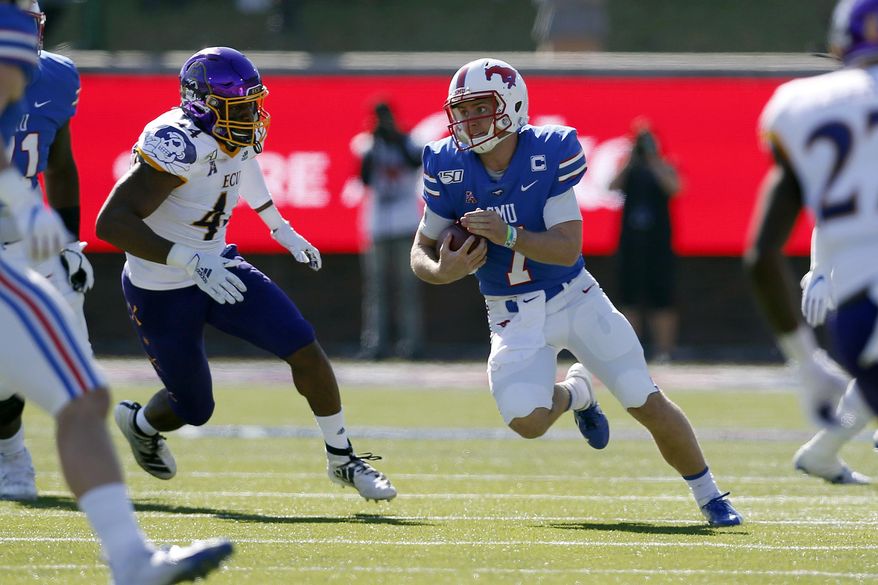 SMU quarterback Shane Buechele (7) looks for room to run while East Carolina cornerback Malik Fleming (4) gives chase during the first half of an NCAA college football game, Saturday, Nov. 9, 2019, in Dallas. (AP Photo/Roger Steinman)