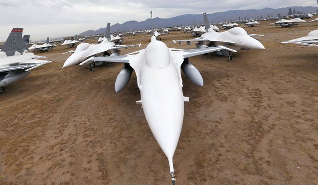 In this May 21, 2015, photo, F-16 Fighting Falcons sit in a field along Miami St. at Davis-Monthan Air Force Base in Tucson, Ariz.  What amounts to a huge dirt parking lot with hundreds of workers is where thousands of U.S. military aircraft go to die. Some go slowly as valuable parts are removed over time for use on other aircraft still in the air, while others will become aerial targets. Some are even put back into duty with U.S. forces. (AP Photo/Matt York) **FILE**
