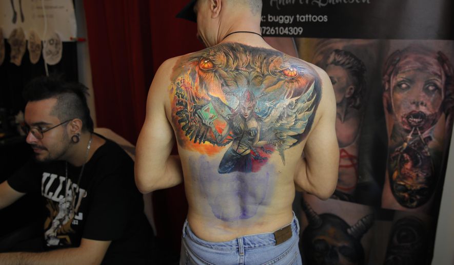 In this Saturday, Nov. 2, 2019, a man waits for ink to dry on a tattoo he&#x27;s getting on his back during the 10th International Tattoo Convention in Bucharest, Romania. (AP Photo/Vadim Ghirda)