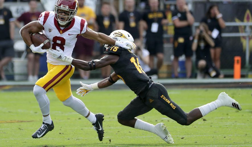 Southern California wide receiver Amon-Ra St. Brown (8) eludes the tackle of Arizona State safety Cam Phillips (15) during the first half of an NCAA college football game, Saturday, Nov. 9, 2019, in Tempe, Ariz. (AP Photo/Matt York)