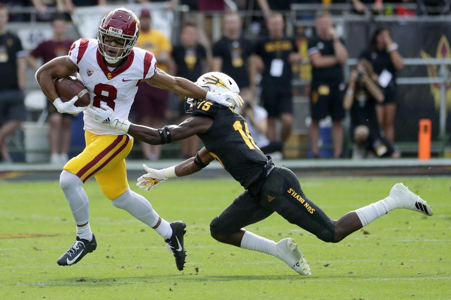 Southern California wide receiver Amon-Ra St. Brown (8) eludes the tackle of Arizona State safety Cam Phillips (15) during the first half of an NCAA college football game, Saturday, Nov. 9, 2019, in Tempe, Ariz. (AP Photo/Matt York)