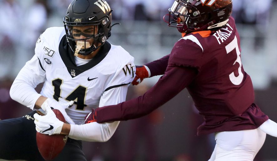 Wake Forest receiver Sage Surratt (14) catches a pass in front of Virginia Tech defender Caleb Farley (3) during the first quarter of an NCAA college football game Saturday, Nov. 9, 2019, in Blacksburg, Va. (Matt Gentry/The Roanoke Times via AP)