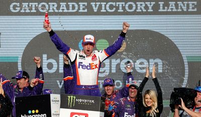 Denny Hamlin celebrates in Victory Lane after his NASCAR Cup Series race win in Avondale, Arizona, on Sunday. Hamlin advanced to next week&#x27;s title race. (ASSOCIATED PRESS)
