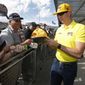 Driver Kyle Busch, right, gives autographs to fans prior to a NASCAR Cup Series auto race at ISM Raceway, Sunday, Nov. 10, 2019, in Avondale, Ariz. (AP Photo/Ralph Freso) ** FILE **
