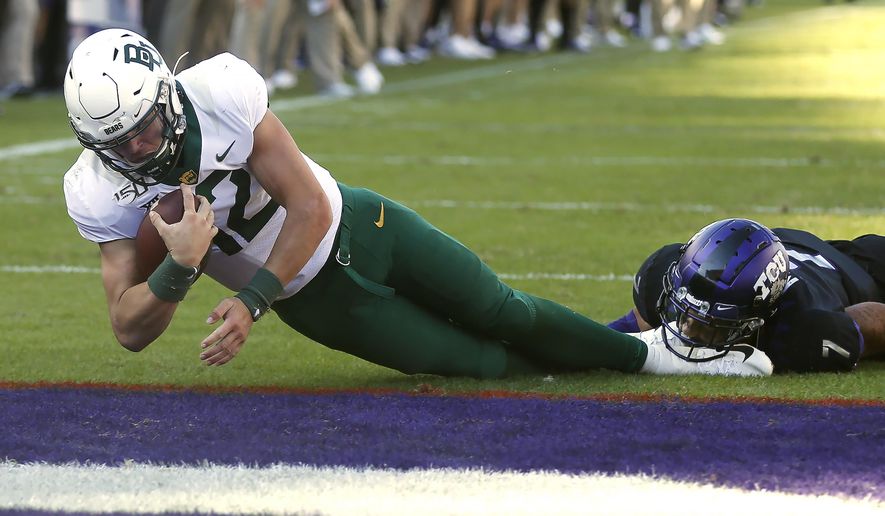 Baylor quarterback Charlie Brewer (12) dives across the goal line to score a touchdown as TCU safety Trevon Moehrig (7) goes to the ground during the second overtime of an NCAA college football game, Saturday, Nov. 9, 2019, in Fort Worth, Texas. Baylor won 29-23 in triple overtime. (AP Photo/Ron Jenkins)