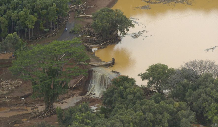 ADVANCE FOR PUBLICATION ON SATURDAY, NOV. 9, AND THEREAFTER - FILE - In this March 14, 2006, file photo, water flows over a breach in an earthen dam at the Kaloko Reservoir in the northeast part of Kauai in Lilhue, Hawaii. An Associated Press investigation shows that virtually every one of Hawaii's 130 state-regulated dams are considered high hazard, meaning they could cause death if they were to fail. (Bruce Asato/The Honolulu Advertiser via AP)