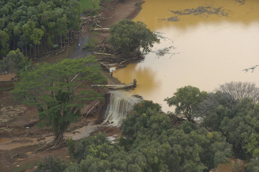 ADVANCE FOR PUBLICATION ON SATURDAY, NOV. 9, AND THEREAFTER - FILE - In this March 14, 2006, file photo, water flows over a breach in an earthen dam at the Kaloko Reservoir in the northeast part of Kauai in Lilhue, Hawaii. An Associated Press investigation shows that virtually every one of Hawaii's 130 state-regulated dams are considered high hazard, meaning they could cause death if they were to fail. (Bruce Asato/The Honolulu Advertiser via AP)