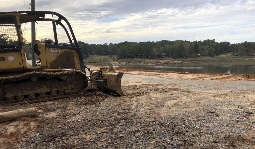 In this Nov. 4, 2019 photograph, a bulldozer rests where crews are rebuilding a dam at the Rainbow Lakes subdivision near Meridian, Miss. The dam is one of a number in Mississippi that could kill someone if it collapses and that inspectors had found to be in poor condition.(AP Photo/Jeff Amy)