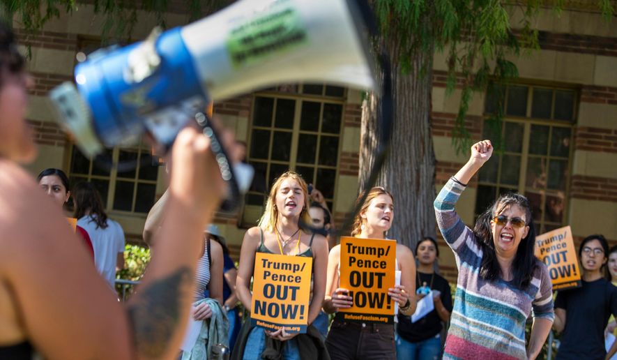 Francisca Vergara, right, yells anti-Trump slogans with protesters during a demonstration outside UCLA's Moore Hall where Donald Trump Jr. was expected to speak while on tour for his new book "Triggered," in Los Angeles, Sunday, Nov. 10, 2019. (Brian van der Brug/Los Angeles Times via AP)