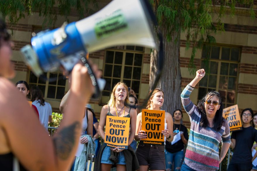 Francisca Vergara, right, yells anti-Trump slogans with protesters during a demonstration outside UCLA's Moore Hall where Donald Trump Jr. was expected to speak while on tour for his new book "Triggered," in Los Angeles, Sunday, Nov. 10, 2019. (Brian van der Brug/Los Angeles Times via AP)