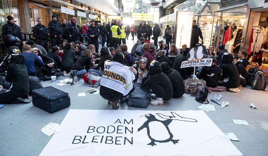 Climate activists block the entrance hall of the Tegel airport in Berlin, Germany, Sunday, Nov. 10, 2019. (Fabian Sommer/dpa via AP)