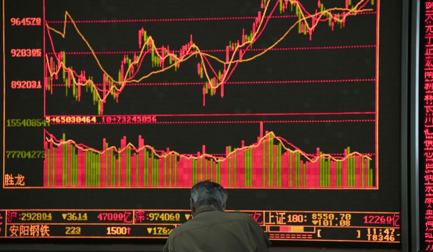 In this Nov. 11, 2019, photo, an investor monitors stock prices at a brokerage in Beijing. Shares were mixed in Asia on Tuesday, Nov. 12, as investors awaited cues on trade talks between China and the U.S. (AP Photo/Ng Han Guan)
