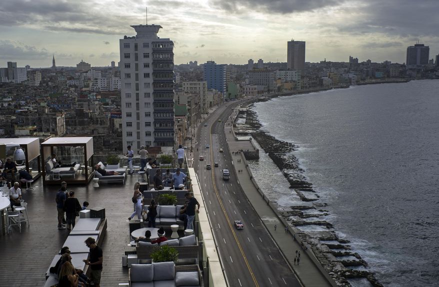 In this Nov. 10, 2019 photo, tourists sit on the terrace of newly opened Hotel Paseo del Prado in Havana, Cuba. The city will celebrate its 500th anniversary on Nov. 16. (AP Photo/Ramon Espinosa)