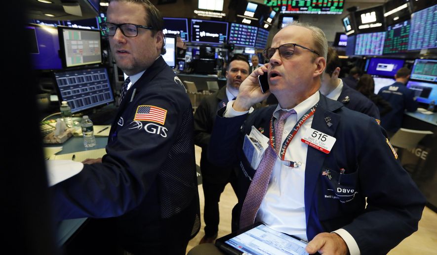 FILE - In this Nov. 7, 2019, file photo specialist Gregg Maloney, left, and trader David O'Day work on the floor of the New York Stock Exchange. The U.S. stock market opens at 9:30 a.m. EST on Monday, Nov 11. (AP Photo/Richard Drew, File)