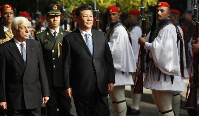 China&#x27;s President Xi Jinping, centre and his Greek counterpart Prokopis Pavlopoulos, left, inspect the guard of honor by Evzones, the Greek Presidential guards, outside the Presidential palace in Athens, Monday, Nov. 11, 2019. Xi Jinping is in Greece on a two-day official visit. (AP Photos/Thanassis Stavrakis)