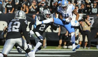 Detroit Lions wide receiver Marvin Jones Jr. (11) catches a touchdown pass against Oakland Raiders&#39; Daryl Worley (20) and Karl Joseph (42) during the first half of an NFL football game in Oakland, Calif., Sunday, Nov. 3, 2019. (AP Photo/John Hefti)
