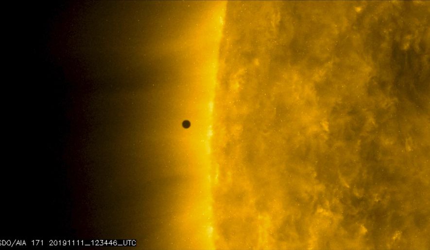 This still image from video issued by NASA's Solar Dynamics Observatory shows Mercury as it passes between Earth and the sun on Monday, Nov. 11, 2019. The solar system's smallest, innermost planet resembles a tiny black dot during the transit, which began at 7:35 a.m. EST (1205 UTC). (NASA Solar Dynamics Observatory via AP)