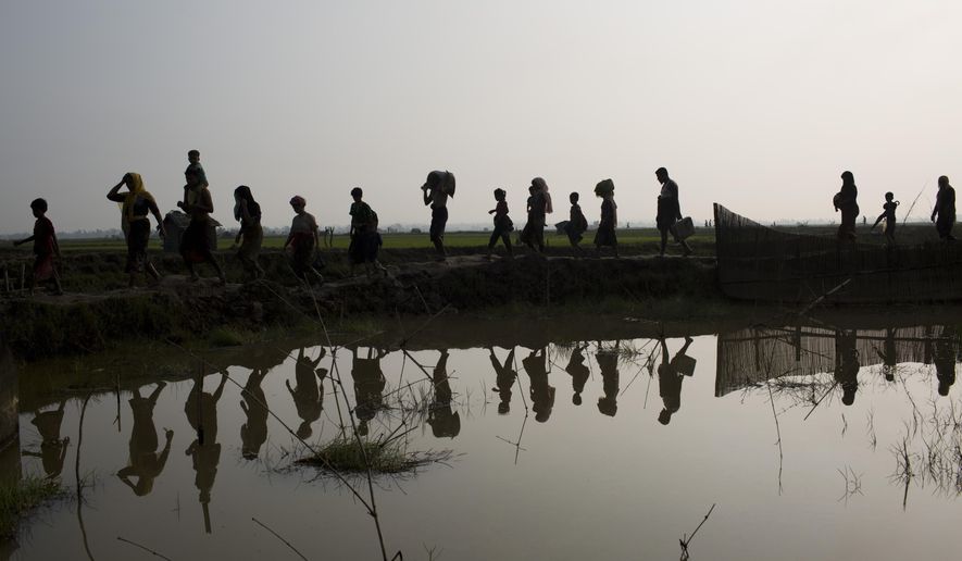 -FILE- In this Tuesday, Sept. 5, 2017, file photo members of Myanmar&#x27;s Rohingya ethnic minority walk through rice fields after crossing the border into Bangladesh near Cox&#x27;s Bazar&#x27;s Teknaf area. Gambia has filed a case at the United Nations&#x27; highest court in The Hague, Netherlands, Monday, Nov. 11, 2019, accusing Myanmar of genocide in its campaign against the Rohingya Muslim minority. A statement released Monday by lawyers for Gambia says the case also asks the International Court of Justice to order measures &amp;quot;to stop Myanmar&#x27;s genocidal conduct immediately.&amp;quot; (AP Photo/Bernat Armangue, file)