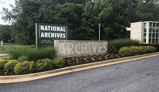 FILE - This June 18, 2019, file photo shows a sign for the entrance to the National Archives in College Park, Md. A Virginia National Guard sergeant accused of stealing World War II-era dog tags from the National Archives and Records Administration in Maryland has pleaded guilty to a theft charge. (AP Photo/Michael Kunzelman, File)