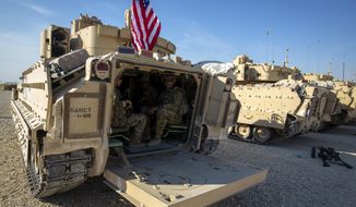 Crewmen sit inside Bradley fighting vehicles at a US military base at an undisclosed location in Northeastern Syria, Monday, Nov. 11, 2019. The deployment of the mechanized force comes after US troops withdrew from northeastern Syria, making way for a Turkish offensive that began last month. (AP Photo/Darko Bandic)