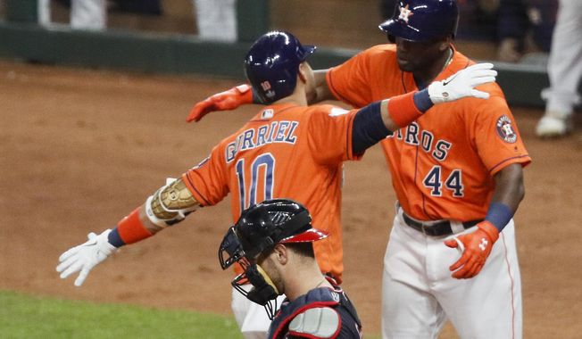 Houston Astros&#x27; Yuli Gurriel (10) celebrates with Yordan Alvarez past Washington Nationals catcher Yan Gomes after his home run during the second inning of Game 7 of the baseball World Series Wednesday, Oct. 30, 2019, in Houston. (AP Photo/Sue Ogrocki)