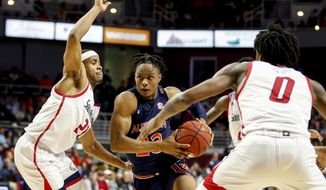 Auburn forward Isaac Okoro (23) drives to the basket between South Alabama guard Chad Lott (21) and forward KK Curry (0) during the first half of an NCAA college basketball game, Tuesday, Nov. 12, 2019, in Mobile, Ala. (AP Photo/Butch Dill)