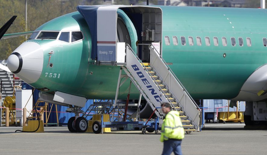 In this April 26, 2019, file photo a worker walks past a Boeing 737 MAX 8 airplane being built for Oman Air at Boeing&#x27;s assembly facility in Renton, Wash. Orders and deliveries of new Boeing planes remain depressed eight months into the grounding of the company&#x27;s 737 Max, Boeing said Tuesday, Nov. 12. (AP Photo/Ted S. Warren, File) **FILE**