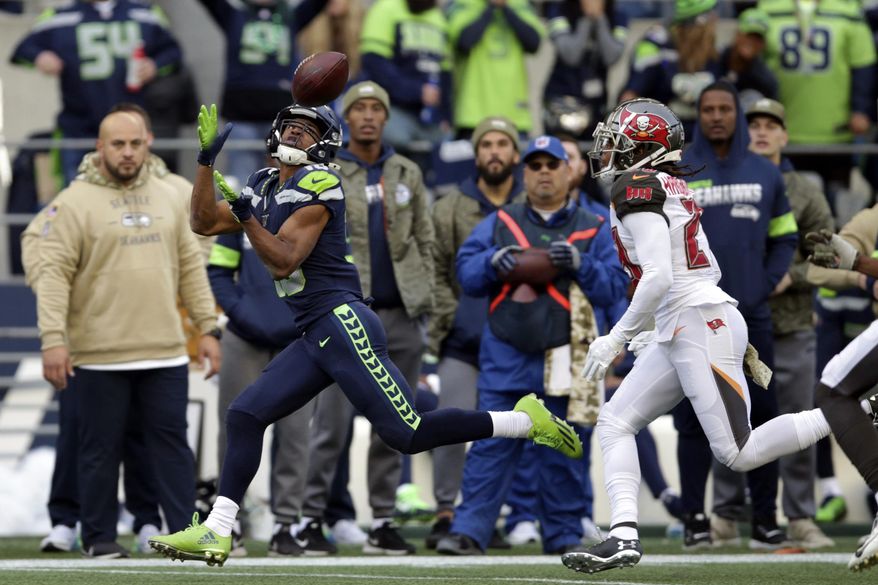 Seattle Seahawks wide receiver Tyler Lockett, left, catches a pass ahead of Tampa Bay Buccaneers cornerback Vernon III Hargreaves, right, during the second half of an NFL football game, Sunday, Nov. 3, 2019, in Seattle. (AP Photo/Scott Eklund)